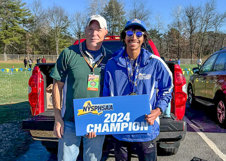 Student and coach with sign