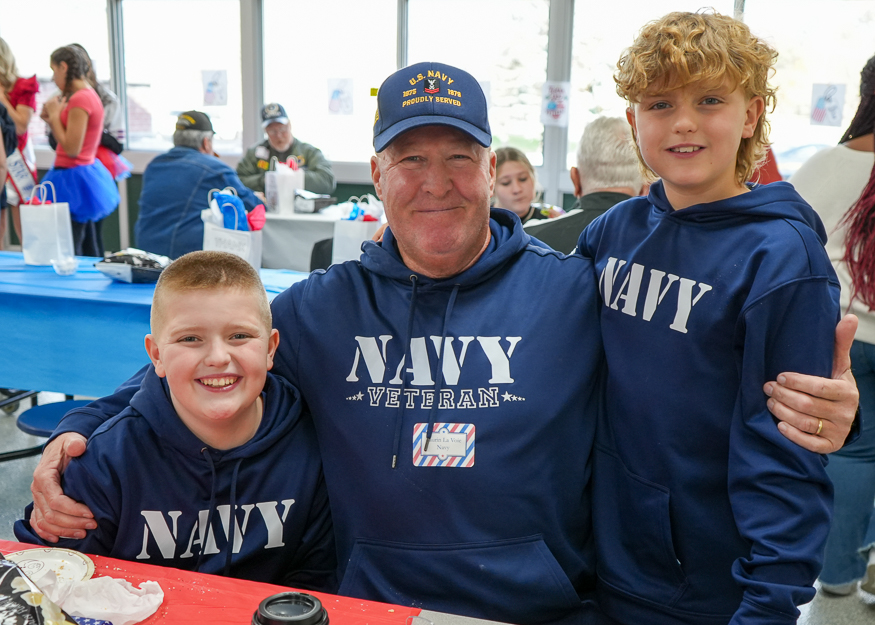 Students and veteran pose for photo