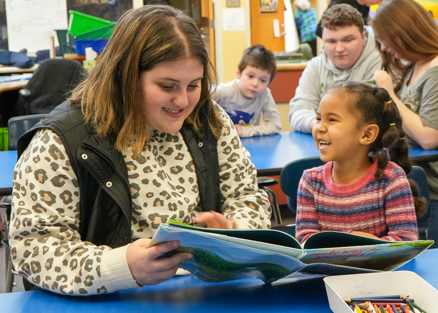 High School student reads to younger student