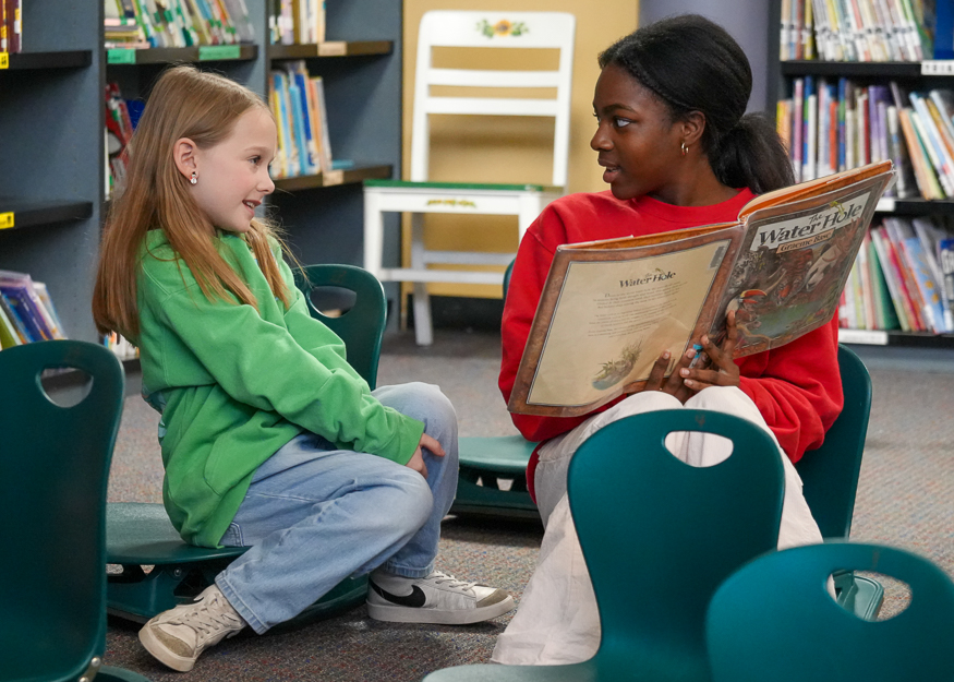 High School student reads to younger student