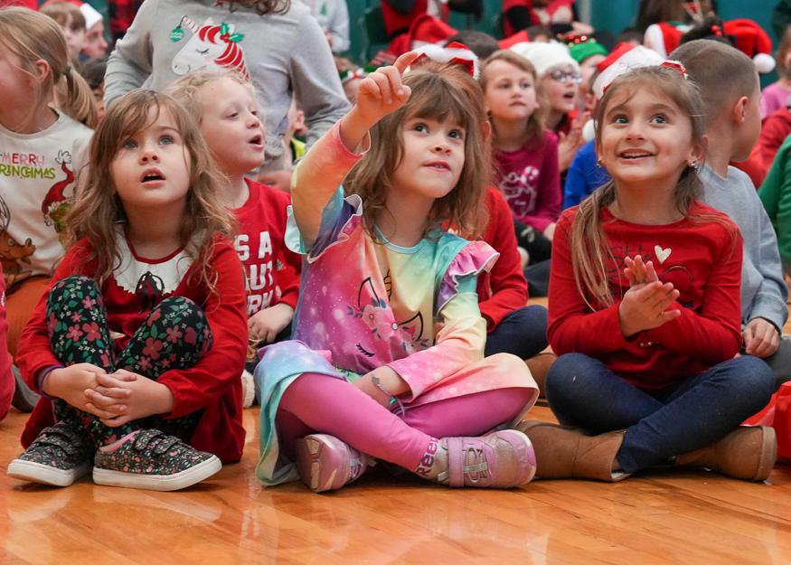 Students sing on gym floor