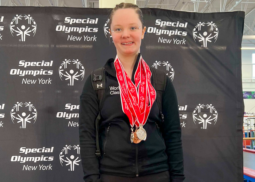 Student poses for photo with medals