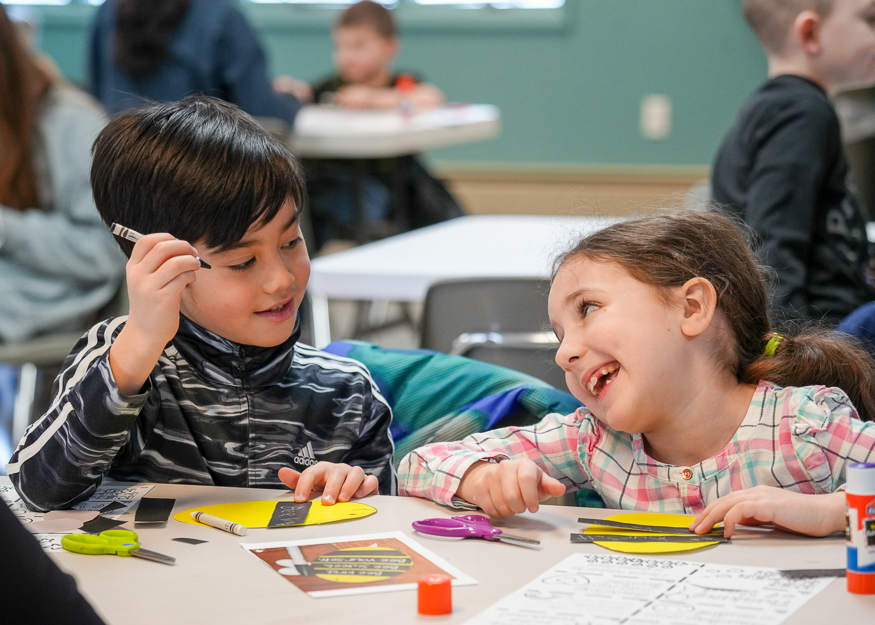 Students smile while doing craft